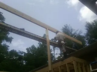 Carpenter setting a ridge beam over a new addition frame — Ice Dam Removal by Roofing Brothers in Scotts Hill