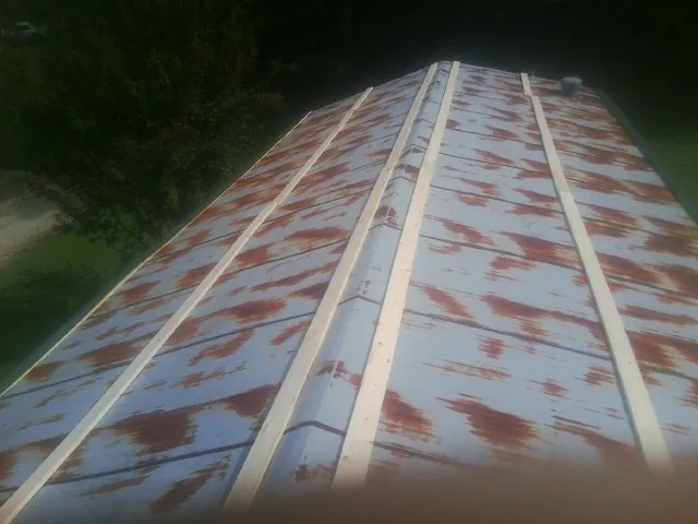 Rusted metal roof panels with new wood purlins before replacement — Storm Damage Roof Repair in Scotts Hill by Roofing Brothers