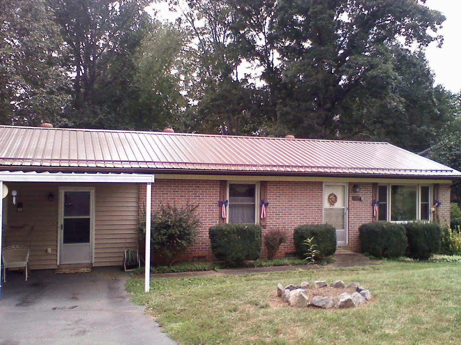 Bronze metal roof and carport on a brick ranch home — Roof Repair work by our crew in Scotts Hill
