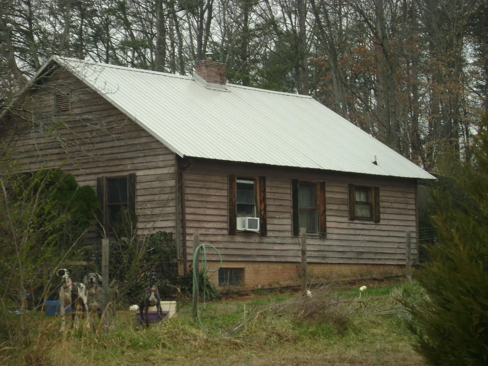White metal roof on an old wood sided farmhouse, from a Metal Roof Installation job in Scotts Hill